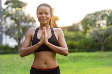 parkta Tayland'da gün batımında yoga yapan kız