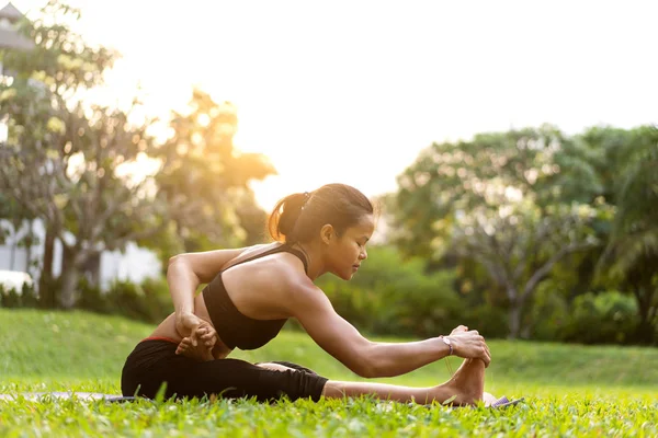 Parkta Tayland'da gün batımında yoga yapan kız — Stok fotoğraf