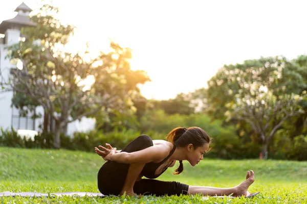 Parkta Tayland'da gün batımında yoga yapan kız — Stok fotoğraf