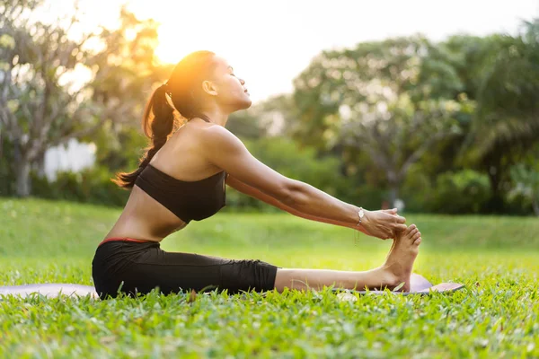 Chica haciendo yoga al atardecer en Tailandia en el parque —  Fotos de Stock