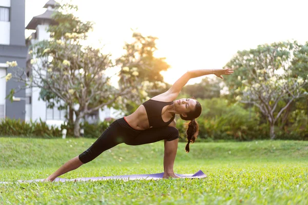 Parkta Tayland'da gün batımında yoga yapan kız — Stok fotoğraf