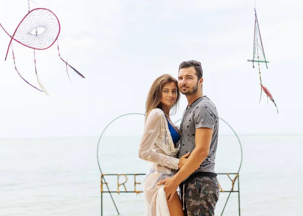 Paar in liefde in tropische palmen bij de zee bij zonsondergang, achteraanzicht — Stockfoto