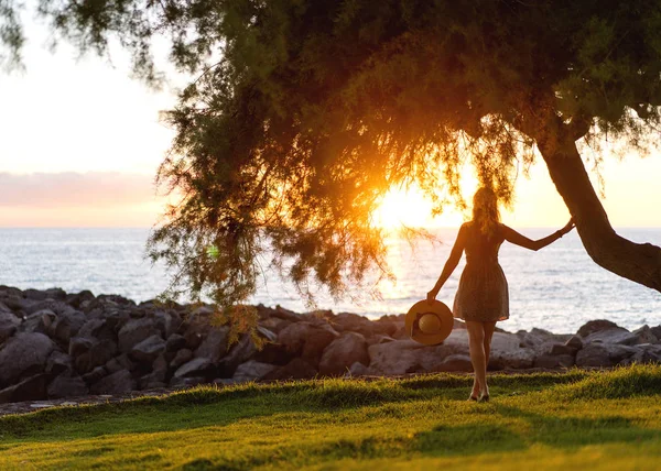 Fille marche sur la plage au coucher du soleil — Photo