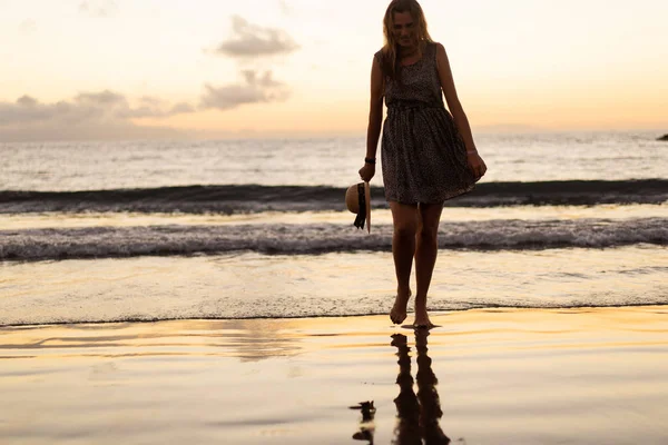 La fille est au coucher du soleil sur la plage — Photo