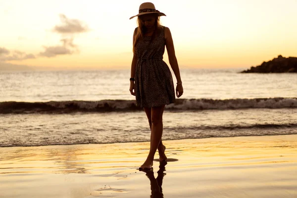 Jambes de fille au coucher du soleil sur la plage — Photo