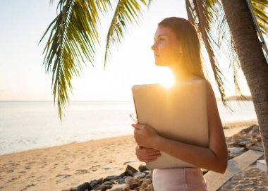 Tropikal palmiye ağaçları arasında serbest çalışan kız adada çalışıyor.