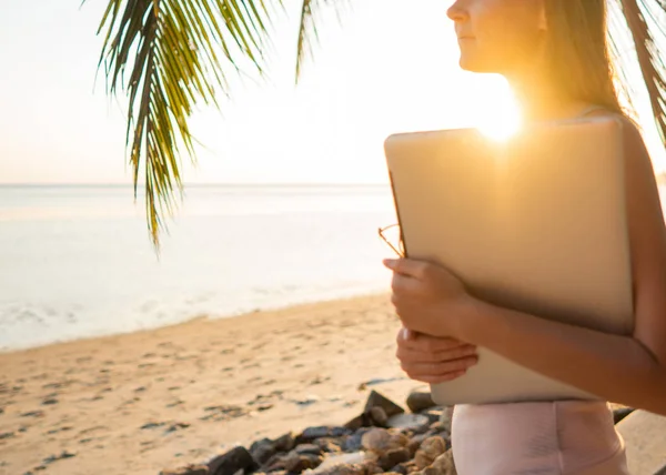 Szabadúszó lány számítógép között trópusi pálmafák dolgoznak a szigeten naplementében — Stock Fotó