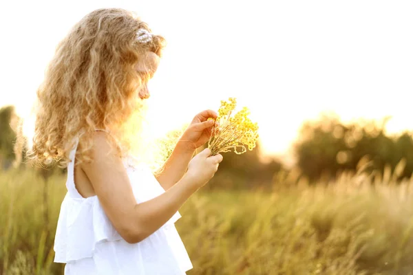 Malá holčička v zapadajícím slunci hraje v terénu — Stock fotografie