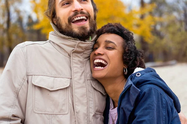 Fyr med en afrikansk amerikansk pige forelsket i efteråret park gåtur ved solnedgang - Stock-foto