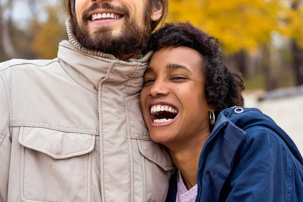 Chlap s africkou americkou dívkou v lásce v podzimním parku procházka při západu slunce — Stock fotografie