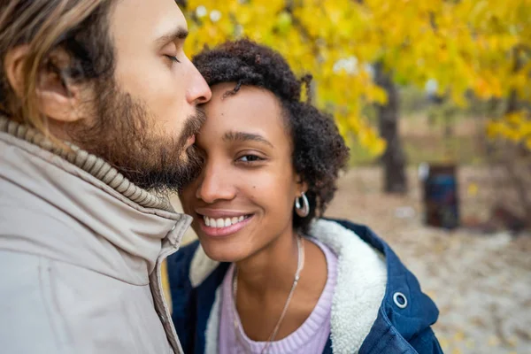 Kerl mit einem verliebten afrikanisch-amerikanischen Mädchen beim herbstlichen Parkspaziergang bei Sonnenuntergang — Stockfoto