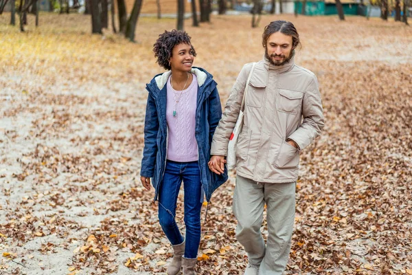Guy with an african american girl in love in autumn park walk at sunset — Stock Photo, Image