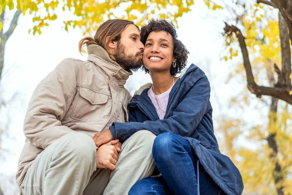 Chico con un afroamericano chica en amor en otoño parque caminar al atardecer — Foto de Stock