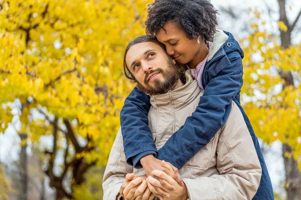 Ragazzo con una ragazza afro-americana innamorata in autunno parco passeggiata al tramonto — Foto Stock