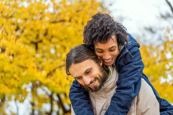 Ragazzo con una ragazza afro-americana innamorata in autunno parco passeggiata al tramonto — Foto Stock
