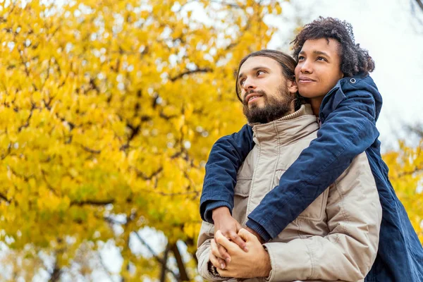 Chico con un afroamericano chica en amor en otoño parque caminar al atardecer — Foto de Stock
