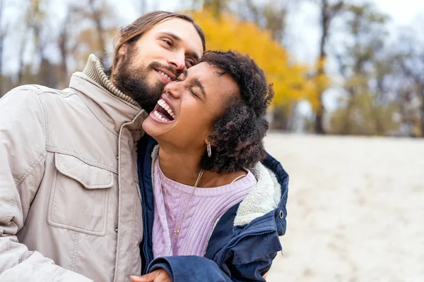 Kerl mit einem verliebten afrikanisch-amerikanischen Mädchen beim herbstlichen Parkspaziergang bei Sonnenuntergang — Stockfoto