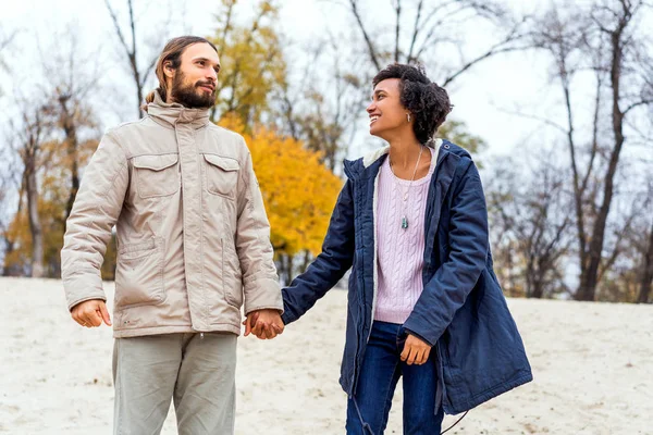 Mec avec une afro-américaine fille en amour en automne parc promenade au coucher du soleil — Photo