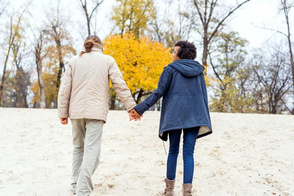 Chico con un afroamericano chica en amor en otoño parque caminar al atardecer — Foto de Stock