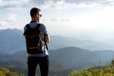 Turist adam Tayland 'da dağların kıyısında duruyor.