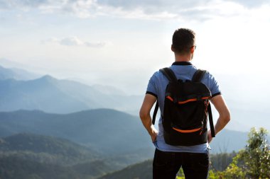 Turist adam Tayland 'da dağların kıyısında duruyor.