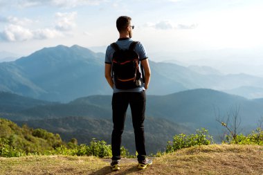 Turist adam Tayland 'da dağların kıyısında duruyor.