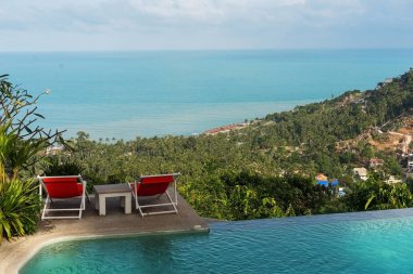 Tayland 'da havuz kenarında deniz kenarında iki güneşlik.