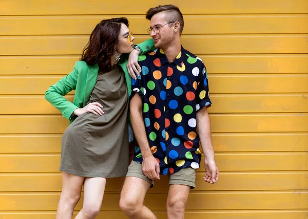 Young fashionable couple on yellow background — Stock Photo, Image