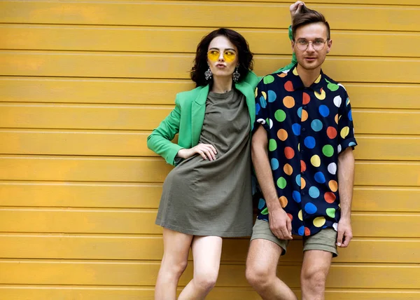 Jeune couple à la mode sur fond jaune — Photo