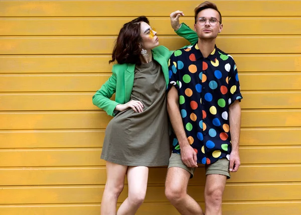 Unga fashionabla par på gul bakgrund — Stockfoto