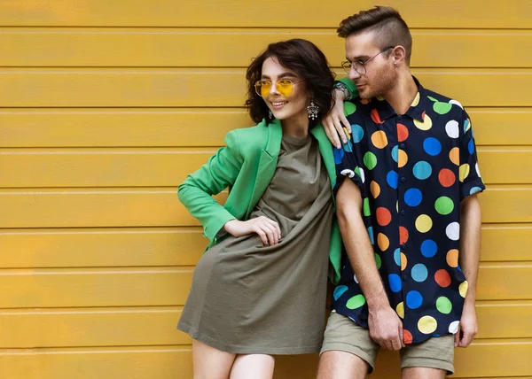 Casal na moda jovem em fundo amarelo — Fotografia de Stock