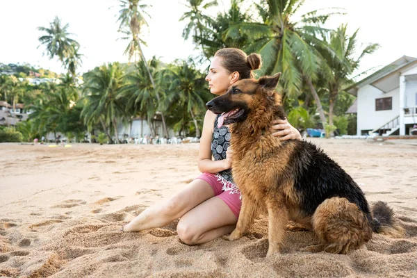 Dívka se psem na tropické pláži mezi palmami a pískem v Thajsku — Stock fotografie