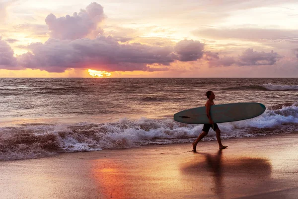 Surfista asociado al atardecer junto al océano en Bali — Foto de Stock