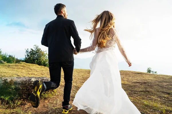 Coppia innamorata in montagna in abiti da sposa al tramonto — Foto Stock