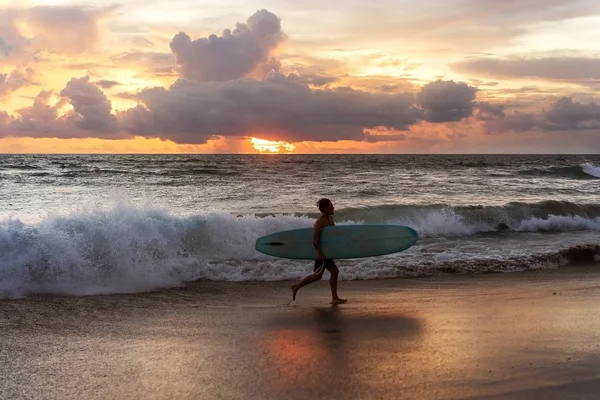 Ortak sörfçü Bali 'de okyanus kenarında gün batımında — Stok fotoğraf