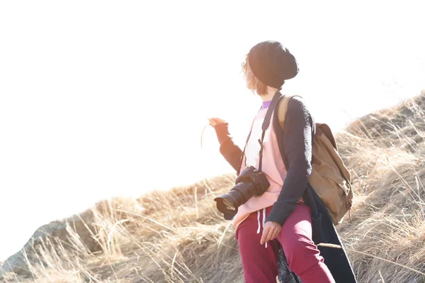 Mulher hipster-fotógrafa com câmera dslr. Menina elegante em óculos de sol com uma câmera na natureza — Fotografia de Stock