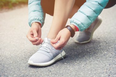 Kız runner dantel bir parkta yolda onu ayakkabı koşu için bağlama. Koşu ayakkabıları, ayakkabı bağcığı. Egzersiz kavramı. Spor yaşam tarzı. Vintage tarzı