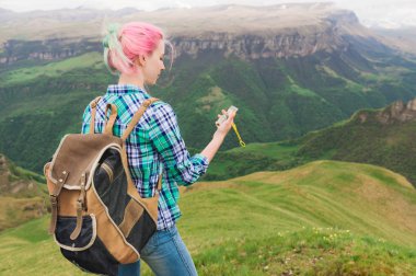 Ekose gömlekli bir blogger ile ve bir plato ile beyaz manzara arka planda arka planda bir pusula kullanarak çok renkli saçlı bir hippi kız gitti