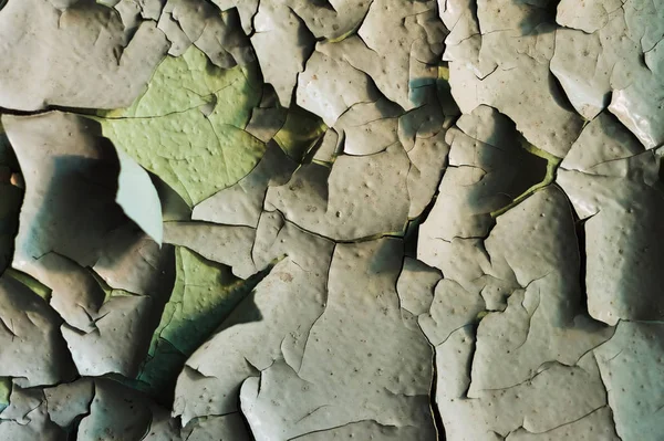 Uma superfície com uma pintura rachada velha que divide partes grandes — Fotografia de Stock