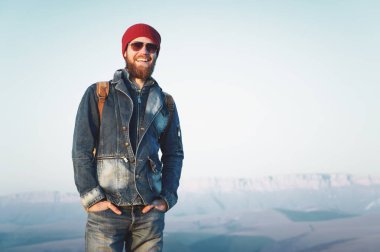 Sakal ve bıyık Dağları arka planı poz güneş gözlüğü takıyor hipster genç adamla