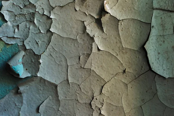 Una superficie con una vieja pintura agrietada dividiendo piezas grandes — Foto de Stock