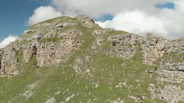 Antena: Lot nad urwiskiem wysokiej skale, odsłaniając widok z przełęczy w Rosji na Kaukazie Północnym. Fotografia lotnicza drogi w wystawiającym słońcu. Lot obok rock — Wideo stockowe