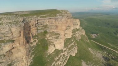 Anteni: uçuş yüksek rock uçuruma Rusya Kuzey Kafkasya'da geçişte bir görünümünü ifşa. Batan güneşin yolda hava fotoğrafçılığı. Uçuş taşın yanındaki