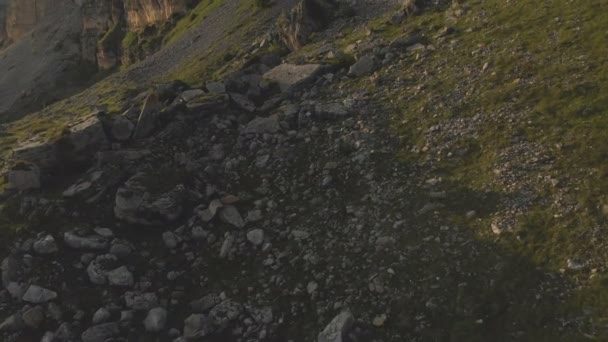 Flight along the rocky cliffs at the foot of the epic cliffs of the plateau in the North Caucasus. Aerial photography Flight over green fields strewn with stones in 4k 100mbps — Stock Video