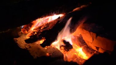 Bir yangın taşlarla vahşi doğanın bir arka plan üzerinde büyük yangını. Yakın çekim seyahat, macera sıcak alev. Temiz hava ormanda sıcak bir akşam. Ahşap odun yanan