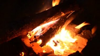 Bir yangın taşlarla vahşi doğanın bir arka plan üzerinde büyük yangını. Yakın çekim seyahat, macera sıcak alev. Temiz hava ormanda sıcak bir akşam. Ahşap odun yanan