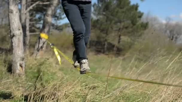 Slackliner 时髦的步行 Slackly 在风的背景下高加索山的蓝天和云彩 — 图库视频影像