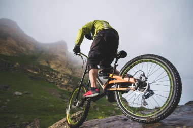Kask açık havada kayalar bir arka plan karşı sürme içinde aşırı dağ bisiklet spor atlet adamı. Bir yaşam tarzı. Deneme