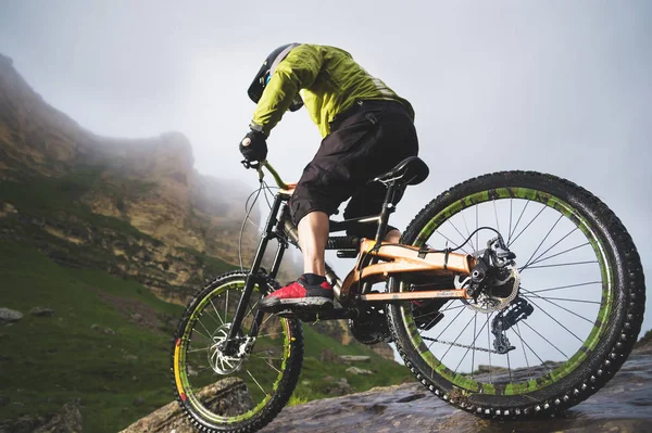 Extreme mountain bike atleta sportivo uomo in casco a cavallo all'aperto su uno sfondo di rocce. Stile di vita. Processo — Foto Stock