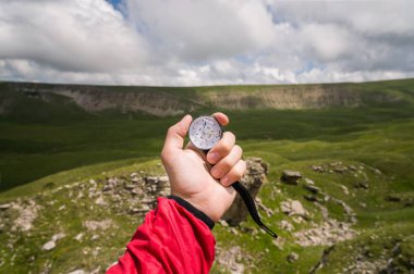 A bir dağ manzarası arka plan üzerinde otantik bir pusula ile el bir turist mans